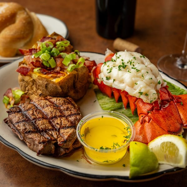 Sterling's surf and turf with steak, lobster tail, loaded baked potato, and butter.