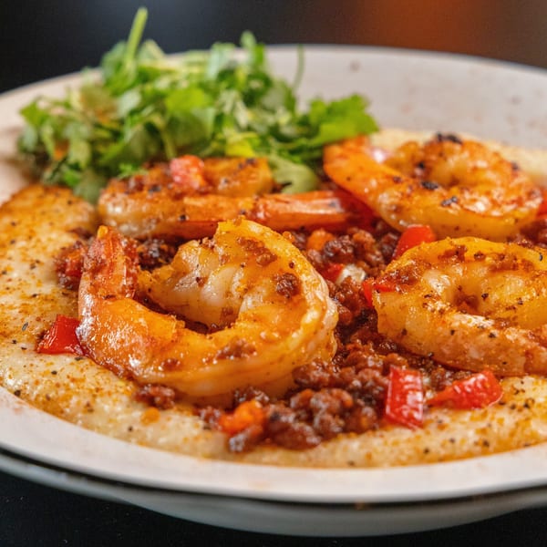 Sterling's shrimp and grits breakfast dish with greens, red peppers, and spices.