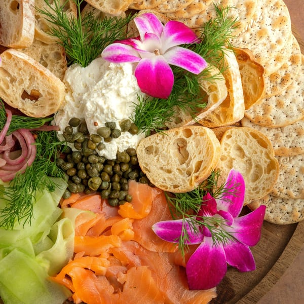 A Sterling's breakfast platter with smoked salmon, capers, cream cheese, bread, crackers, and dill.