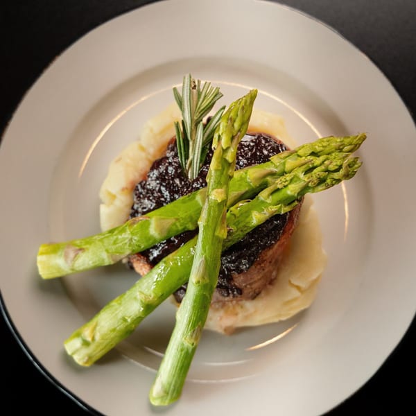 Sterling's Restaurant breakfast: a dish with mashed potatoes, meat, dark sauce, asparagus, and rosemary.